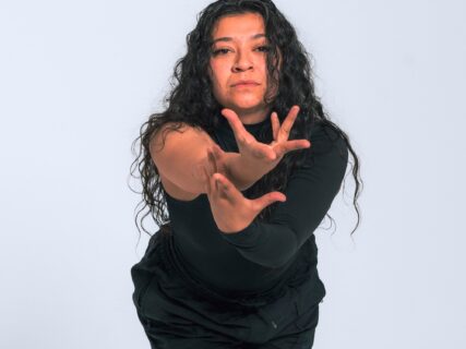 Dancer reaching toward the camera mid-movement during a hip hop class at East & Co.