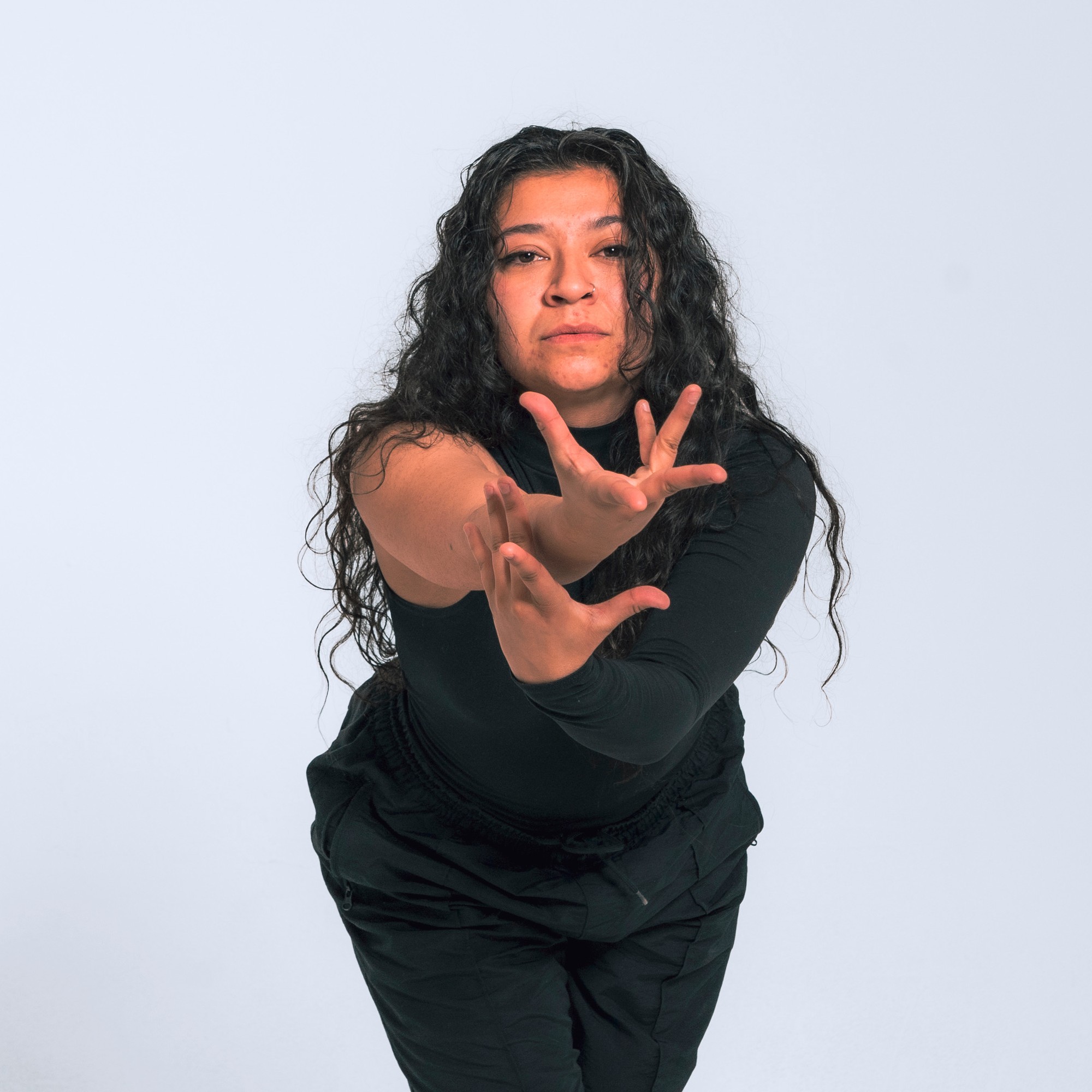 Dancer reaching toward the camera mid-movement during a hip hop class at East & Co.